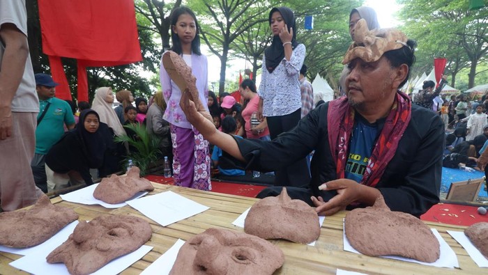 Intip Pembuatan Topeng Panji dari Serbuk Kayu di Kediri Dua peserta menempelkan serbuk kayu yang telah dicampur dengan lem pada kertas karton saat lokakarya pembuatan topeng di Kabupaten Kediri, Jawa Timur, Minggu (25/5/2025). Lokakarya yang diselenggarakan pemerintah daerah setempat tersebut sebagai upaya memberi pengetahuan cara membuat topeng karakter panji ramah lingkungan sekaligus mengingatkan masyarakat bahwa Kediri sebagai Bumi Panji. ANTARA FOTO/Prasetia Fauzani