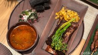 Kreasi chef Benvi tak hanya berhenti pada pemilih menu. Untuk Konro Bakar khas Makassar yang disajikan ia memadukannya dengan singkong goreng charcoal yang sekilas bentuknya mirip arang. Foto: Tim detikfood