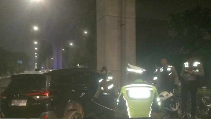 Polisi saat melakukan olah TKP mobil yang dikendarai mahasiswa tabrak tiang LRT Palembang