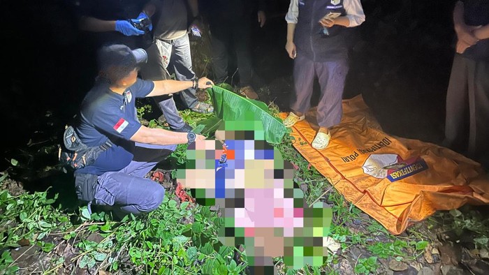 Polisi saat mengevakuasi jasad wanita ditemukan tewas dalam kebun