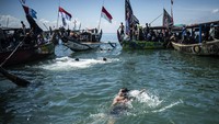 Di tengah laut, prosesi larung sesaji berlangsung khidmat. Seorang warga bahkan terlihat berenang di sekitar lokasi sebagai bagian dari tradisi yang sudah berlangsung turun-temurun ini.