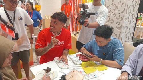 Shayne Pattynama melukis sandal bersama para penggemarnya di Havaianas store Bali Jalan Sunset Road, Sabtu (24/5/2025). (Aryo Mahendro/detikBali).