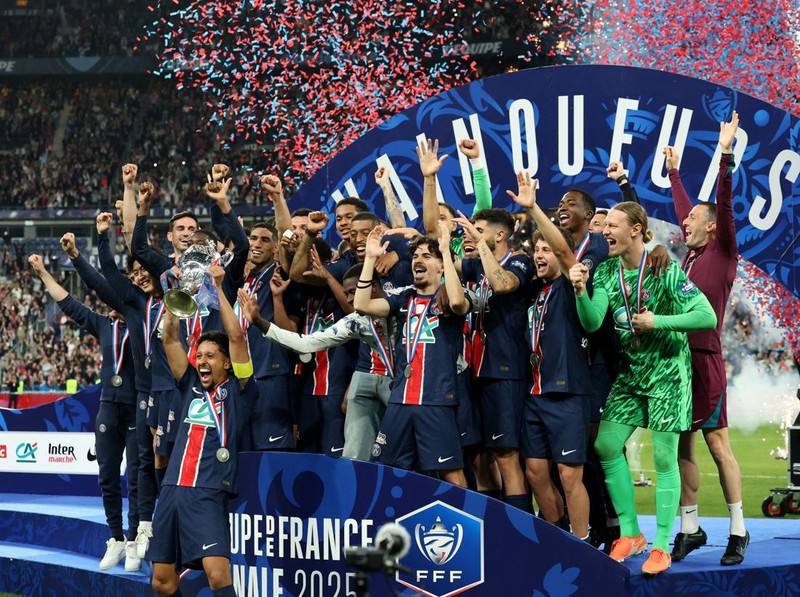 Soccer Football - Coupe de France - Final - Paris St Germain v Stade de Reims - Stade de France, Saint-Denis, France - May 24, 2025 Paris St Germain's Marquinhos lifts the trophy as he celebrates with teammates after winning the Coupe de France REUTERS/Denis Balibouse