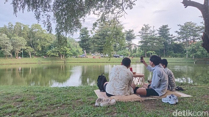 Warga sedang piknik sambil menikmati hidangan dari Kafe Banyuu di taman Pecatu Resort bersama teman, pasangan, dan keluarga, Minggu (25/5/2025). (Aryo Mahendro/detikBali).