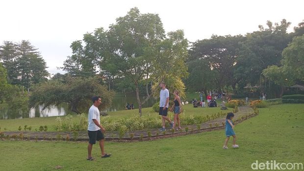 Warga sedang piknik sambil menikmati hidangan dari Kafe Banyuu di taman Pecatu Resort bersama teman, pasangan, dan keluarga, Minggu (25/5/2025). (Aryo Mahendro/detikBali).
