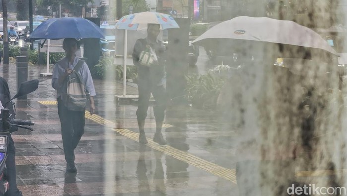 Warga tetap beraktivitas di tengah gerimis yang turun di kawasan Thamrin, Jakarta, pada Senin (26/5/2025). Hujan ringan hingga sedang masih mengguyur sejumlah wilayah Ibu Kota meski kalender menunjukkan awal musim kemarau.