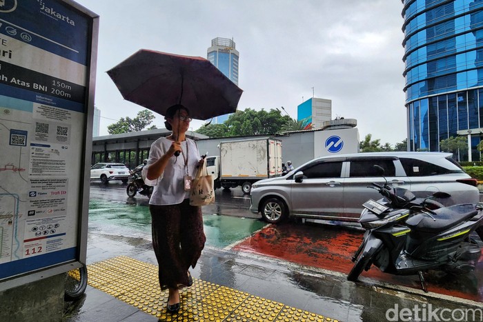 Warga tetap beraktivitas di tengah gerimis yang turun di kawasan Thamrin, Jakarta, pada Senin (26/5/2025). Hujan ringan hingga sedang masih mengguyur sejumlah wilayah Ibu Kota meski kalender menunjukkan awal musim kemarau.