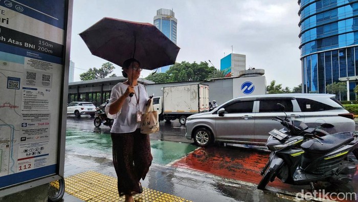Warga tetap beraktivitas di tengah gerimis yang turun di kawasan Thamrin, Jakarta, pada Senin (26/5/2025). Hujan ringan hingga sedang masih mengguyur sejumlah wilayah Ibu Kota meski kalender menunjukkan awal musim kemarau.