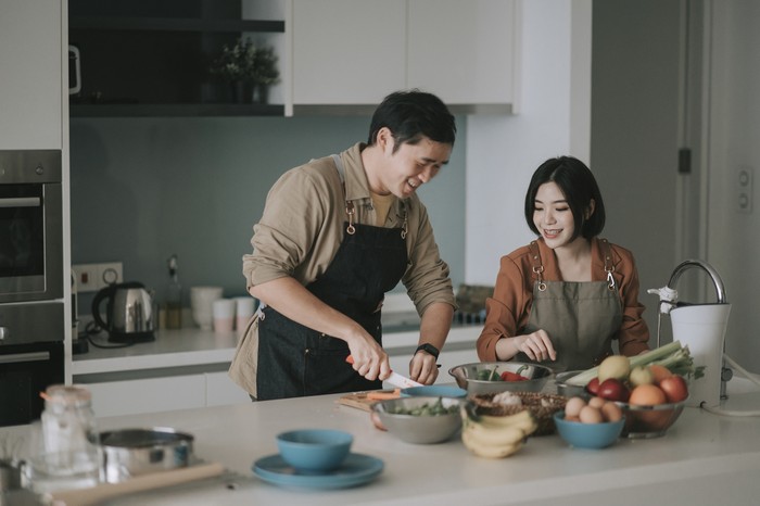 asian chinese couple preparing ingredients cooking meals for family at kitchen counter