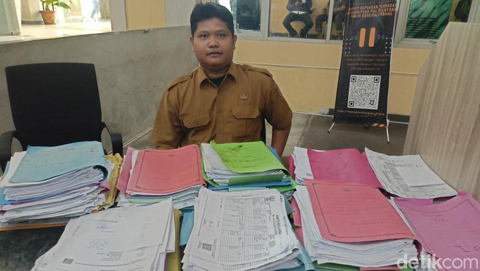 Kepala Tim KIS dan DTKS Kota Palembang Yoga Catur Nugraha menunjukkan tumpukan berkas yang tidak diambil