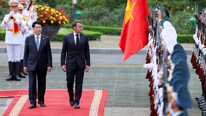Vietnam's President Luong Cuong and French President Emmanuel Macron inspect the honour guard during a welcome ceremony, at the Presidential Palace in Hanoi, Vietnam, May 26, 2025. REUTERS/Chalinee Thirasupa/Pool