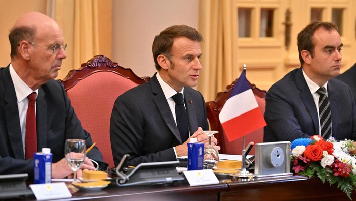 Frances President Emmanuel Macron and Vietnams President Luong Cuong sit with their delegation during a meeting at the Presidential Palace in Hanoi on May 26, 2025.     NHAC NGUYEN/Pool via REUTERS
