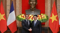 Presiden Prancis Emmanuel Macron dan Presiden Vietnam Luong Cuong berjabat tangan selama pertemuan di Istana Kepresidenan di Hanoi. Nhac Nguyen/Pool via REUTERS