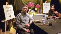 Dalam momen penting itu Kevin memakai kemeja abu-abu dan mendekor lamaran dengan kain hitam dan dua bingkai foto. (Foto: dok Instagram)