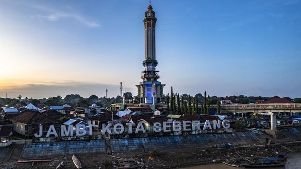 Menikmati Senja di Tepi Sungai Batanghari Jambi Berlatar Menara Gentala Arasy Foto udara suasana senja di perkampungan Seberang Kota Jambi dengan latar Menara Gentala Arasy di tepi Sungai Batanghari, Jambi, Minggu (25/5/2025). Pemerintah Provinsi Jambi sejak 10 tahun terakhir terus mengupayakan penumbuhan titik-titik ekonomi kreatif baru di dua sisi Sungai Batanghari, utamanya di wilayah Pasar Jambi dan Seberang Kota Jambi, melalui pembangunan Taman Menara Gentala Arasy dan Taman Putri Pinang Masak dengan anggaran mencapai Rp120 miliar lebih. ANTARA FOTO/Wahdi Septiawan
