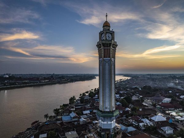 Menikmati Senja di Tepi Sungai Batanghari Jambi Berlatar Menara Gentala Arasy