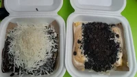 Di Jalan Galur Raya, Johar Baru, ada Pancong Lumer Bang Gemoy yang jadi favorit. Usaha pancong gerobakan ini mematok harga mulai Rp 8 ribuan. Bisa campur 2-3 rasa dengan topping tambahan berupa choco chips hingga keju almond. Foto: Yuliana Vora