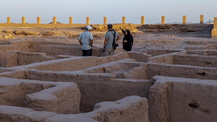 Iranian photographer Herbert Greg Karim Masihi and tourism activists visit a mud-brick structure known as the City of Dwarves, located on the western edge of the Lut Desert near the city of Kerman, 1,335 kilometers (830 miles) southeast of Tehran, Iran, on May 22, 2025. The City of Dwarves of Shahdad, which according to archaeological reports dates back more than five thousand years, is one of the most mysterious ancient sites in Iran. It is located on the western edge of the Lut Desert, near the city of Shahdad in Kerman Province. This ancient city is known as the ''City of Dwarves'' due to its unique architecture and the small size of its houses, alleys, and living facilities. (Photo by Morteza Nikoubazl/NurPhoto via Getty Images)