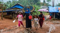 Sejumlah warga penyintas bencana banjir bandang dan longsor berjalan di sekitar hunian sementara (huntara) di Kampung Cigobang, Lebak, Banten, Senin (26/5/2025).