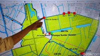 Salah satu penyebab utama banjir di kawasan itu adalah kondisi topografi yang membuat air sulit mengalir keluar secara alami. Permukaan jalan yang lebih rendah dari sungai memperparah akumulasi air hujan.