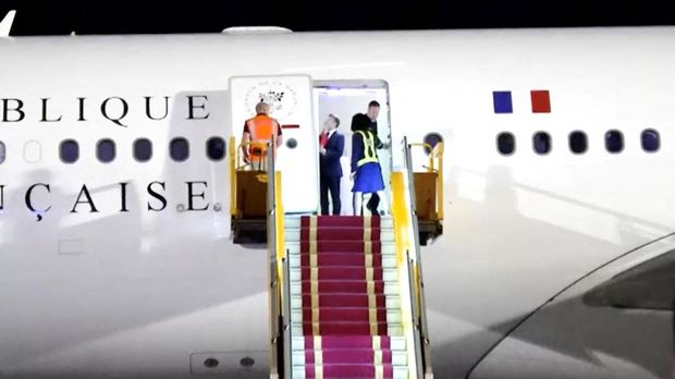 French President Emmanuel Macron stands near the door of a plane, as a hand appears and pushes his face away, in Hanoi, Vietnam, May 25, 2025, in this screengrab from a video. Reuters TV/via REUTERS