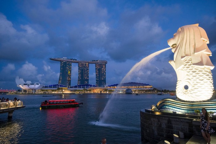 Singapore, the Merlion, statue representing a mythical creature with a lions head and the body of a fish, in Marina Bay. In the background the Marina Bay Sands (hotel and shopping mall). (Photo by: Benard E/Andia/Universal Images Group via Getty Images)