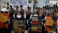 Massa aksi datang dengan membawa sejumlah atribut dan poster yang berisikan protes. 