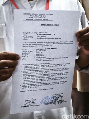 Pengadu rumah makan Ayam Goreng Widuran, Mochamad Burhannudin, saat menunjukkan berkas aduan di Mapolresta Solo, Senin (26/5/2025)