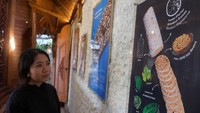 Seorang mahasiswa mengamati gambar mengenai tempe berbahan kedelai saat mengunjungi museum tempe di Tempego Experience, Ubud, Gianyar, Bali, Selasa (27/5/2025). (ANTARA FOTO/Nyoman Hendra Wibowo)