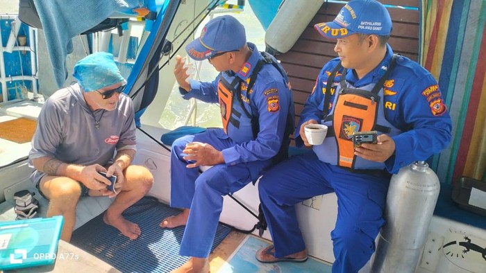 Petugas berbincang dengan salah seorang awak kapal yang kapalnya menepi darurat di Pantai Santolo, Garut.