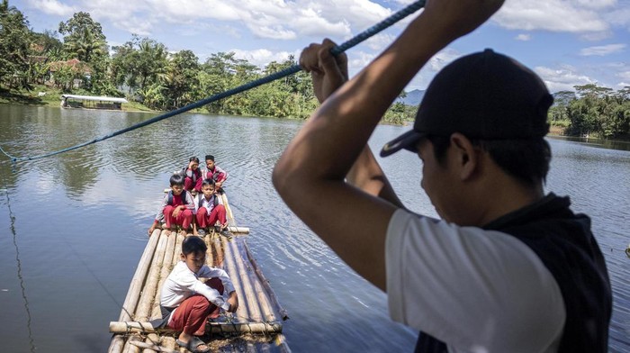 Potret Siswa di Bandung Barat, Seberangi Sungai Pakai Rakit Demi Sekolah Sejumlah siswa SDN Panaruban menyeberangi sungai Cicadas menggunakan rakit di Desa Karanganyar, Cililin, Kabupaten Bandung Barat, Jawa Barat, Selasa (27/5/2025). Sejumlah siswa dan warga dari Kampung Sampora serta Kampung Cijigud sejak tahun 1984 untuk sekolah atau mengakses pelayanan publik terpaksa menyeberangi sungai Cicadas menggunakan rakit guna memangkas waktu perjalanan menjadi 10 menit dibandingkan dengan jalur darat yang mencapai satu jam. ANTARA FOTO/Abdan Syakura