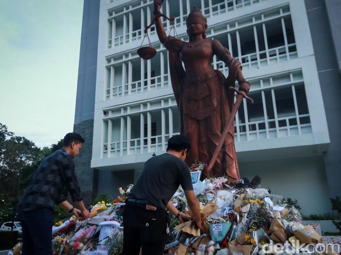 Potret tumpukan bunga di patung Dewi Keadilan Fakultas Hukum UGM, Selasa (27/5/2025). Bunga-bunga itu dikirim oleh teman kuliah Argo.