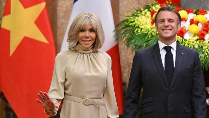 Presiden Prancis Emmanuel Macron dan istrinya Brigitte Macron bereaksi saat berpose untuk foto selama pertemuan di Istana Kepresidenan di Hanoi pada 26 Mei 2025.