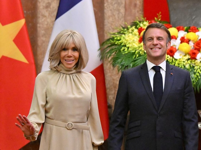 Presiden Prancis Emmanuel Macron dan istrinya Brigitte Macron bereaksi saat berpose untuk foto selama pertemuan di Istana Kepresidenan di Hanoi pada 26 Mei 2025.