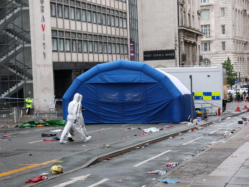 Forensic officers work near the site of an incident where a car plowed into a crowd of Liverpool fans during a parade celebrating their side's Premier League soccer title, in central Liverpool, Britain, May 27, 2025. REUTERS/Phil Noble