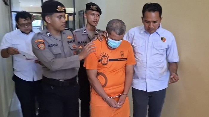Tersangka mengenakan baju tahanan saat digiring polisi.