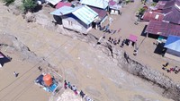 Foto udara yang diambil pada Rabu (28/5) memperlihatkan kondisi jalan di Desa Wombo yang terputus akibat derasnya terjangan banjir. Jembatan yang menghubungkan jalur utama desa pun sebagian hanyut terbawa arus. ANTARA FOTO/Basri Marzuki