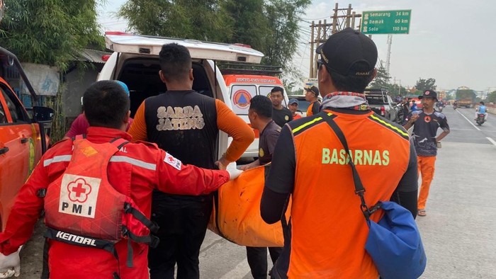 Petugas mengevakuasi mayat korban terseret arus.