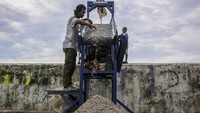 Pekerja memproses cangkang kerang hijau menjadi serpihan di Rumah Produksi Kelompok Kerajinan Cangkang Kering (Cangkring), Cilincing, Jakarta Utara. (ANTARA FOTO/Sulthony Hasanuddin)