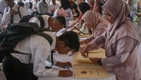 Sejumlah CPNS menandatangi SK saat penyerahan SK CPNS di halaman Balai Kota DKI Jakarta. (ANTARA FOTO/Jasmine Nadhya Thanaya)