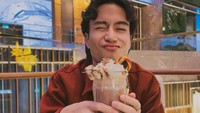 Vidi membagikan pose lucu di sebuah restoran. Ia menggenggam segelas milkshake cokelat dengan aneka topping manis yang melimpah. Foto: Instagram @vidialdiano