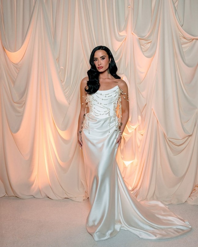 Setelah upacara, wanita 32 tahun ini berganti busana untuk resepsi. Dia mengenakan gaun strapless model column yang dirancang khusus oleh Westwood, dihiasi detail unik berupa untaian mutiara yang menjuntai dari garis leher.  Foto: Instagram/@ddlovato @vogueweddings @josevilla
