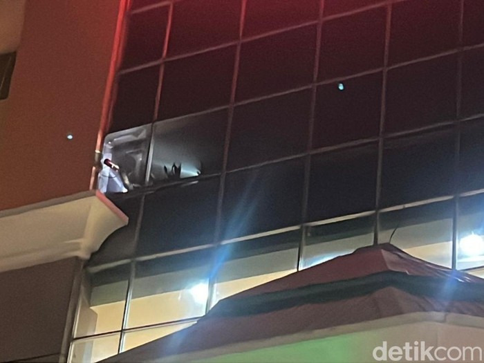 Petugas Damkar memecah kaca depan Solo Grand Mall saat proses pemadaman kebakaran di Foodcourt lantai 3, Kamis (29/5/2025) malam.