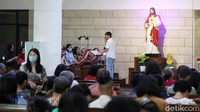 Banyak umat datang bersama keluarga, mengenakan pakaian terbaik dan membawa buku doa pribadi.