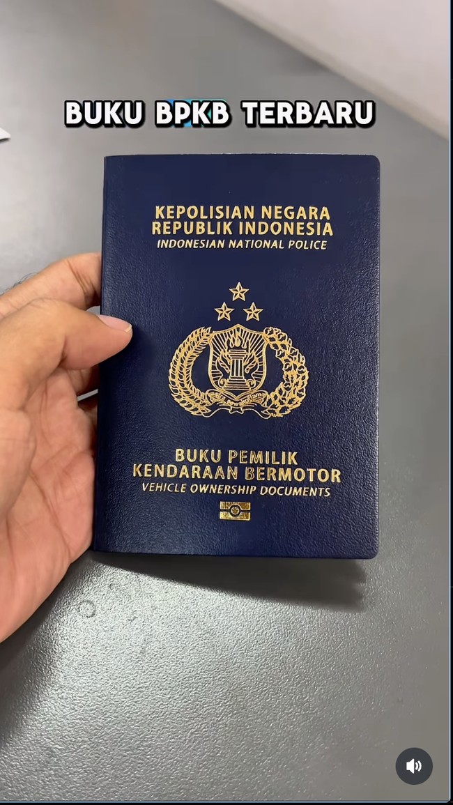 Sebuah gambar yang menampilkan tangan memegang smartphone dengan layar menampilkan informasi kendaraan digital, sementara di latar belakang terlihat BPKB elektronik modern dengan logo kepolisian. Nuansa teknologi tinggi dan keamanan terasa dalam visual.