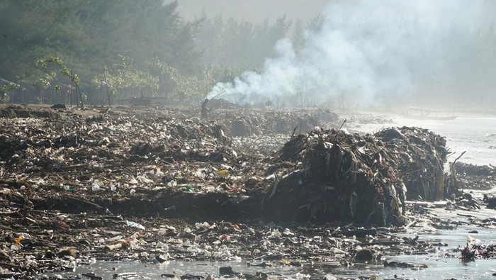 Wisatawan bermain air meski sampah memenuhi sepanjang pesisir Pantai Gemah, Tulungagung, Jawa Timur, Jumat (30/5/2025). Timbunan sampah yang diperkirakan mencapai 10 ribu kubik lebih di sepanjang garis pantai Teluk Popoh itu muncul sejak dua pekan terakhir atau pascabanjir bandang yang melanda sejumlah wilayah di Tulungagung dan Trenggalek yang kemudian terbaawa hingga muara Sungai melalui pintu Bendung Neyama. ANTARA FOTO/Destyan Sujarwoko/foc.
