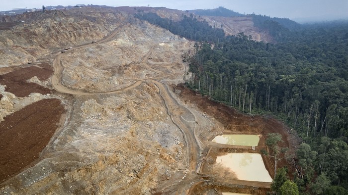 This aerial photo taken on April 16, 2025 shows a general view of a nickel mining site and the edge of the forest where Bokum, a member of the Hongana Manyawa indigenous tribe, regularly patrols to monitor mining activity in East Halmahera, North Maluku. Sitting deep in east Indonesias lush jungle, Bokum, one of the countrys last isolated hunter-gatherers, has a simple message for the nickel miners threatening his forest home: This is our land. (Photo by AFP) / To go with INDONESIA-ENVIRONMENT-POLLUTION-FORESTS-RIGHTS-MINING-ENERGY-METAL, SPECIAL REPORT by Jack Moore and Bagus Saragih
