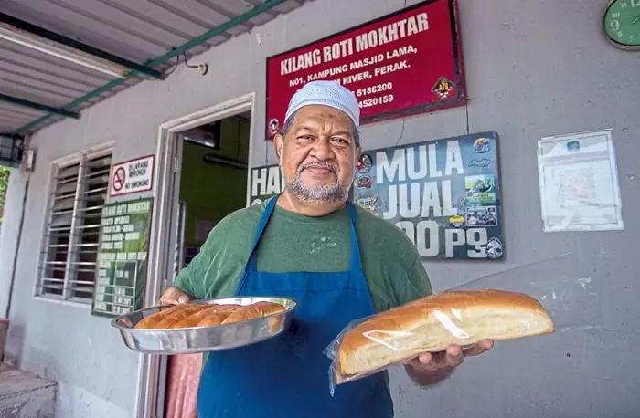 Toko Roti Rumahan Sejak 1949 Masih Bertahan hingga Generasi KetigaRoti yang dibuat secara tradisional dengan dibakar di dalam kebuk bata merah menggunakan kayu api dan tempurung kelapa. Keenakan roti yang manis dan lembut berbaur asap kayu itu memberikan pengalaman tersendiri bagi yang pertama kali mencuba. Kilang Roti Mokhtar ini masih bertahan merentasi masa sejak beroperasi pada 1949, sekalipun bersaing dengan pelbagai jenis roti berjenama yang mudah didapati di pasaran.--fotoBERNAMA (2025) HAK CIPTA TERPELIHARA