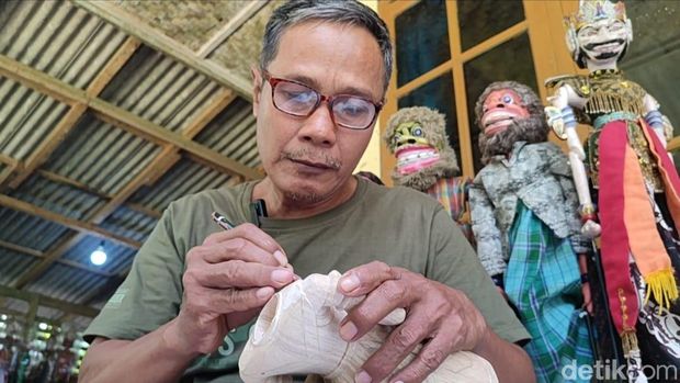 Udis yang sedang mengukir wayang golek di kediamannya Desa Sukaresik, Kecamatan Sidamulih, Kabupaten Pangandaran