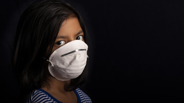 Portrait of little girl wearing a medical mask used for virus protection